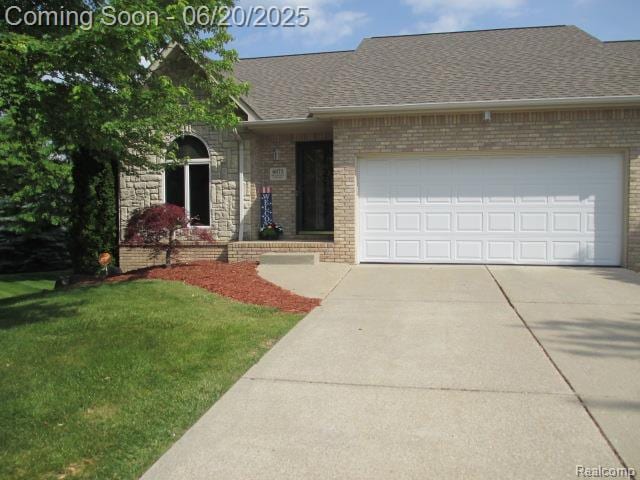 6073 Belmont Ct E, Grand Blanc, MI 48439 - view of front facade with an attached garage, driveway, brick siding, and a shingled roof