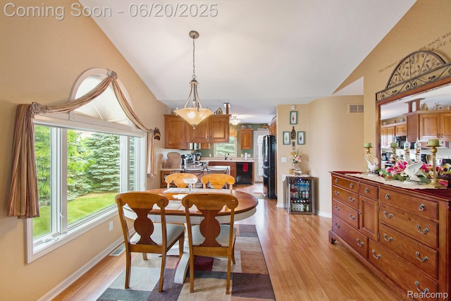 6073 Belmont Ct E, Grand Blanc, MI 48439 - dining room with lofted ceiling, light wood-style flooring, and wine cooler