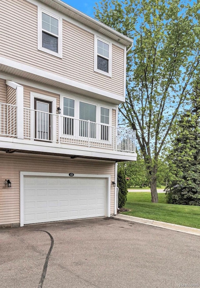 478 N Wixom Rd, Wixom, MI 48393 - view of front of property featuring an attached garage, driveway, and a balcony