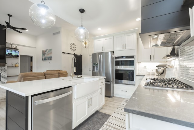 21536 Fieldview Dr, Edwardsburg, MI 49112 - kitchen featuring appliances with stainless steel finishes, open floor plan, decorative backsplash, a barn door, and recessed lighting