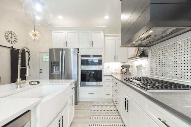 21536 Fieldview Dr, Edwardsburg, MI 49112 - kitchen with stainless steel appliances, wall chimney range hood, white cabinetry, backsplash, and recessed lighting