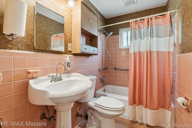 1972 Theodore St, Trenton, MI 48183 - bathroom with tile walls, shower / bath combo with shower curtain, wallpapered walls, and a wainscoted wall