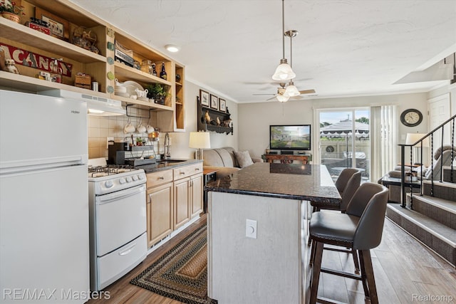 1972 Theodore St, Trenton, MI 48183 - kitchen featuring white appliances, a ceiling fan, dark wood-style flooring, a kitchen bar, and tasteful backsplash