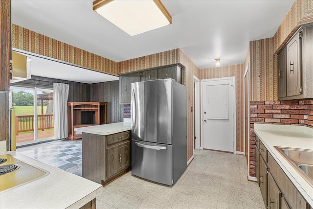 360 Wood Creek Dr, Howell, MI 48843 - kitchen featuring freestanding refrigerator, wallpapered walls, light floors, light countertops, and a peninsula