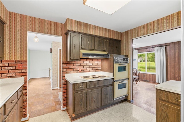 360 Wood Creek Dr, Howell, MI 48843 - kitchen featuring wallpapered walls, exhaust hood, double oven, light countertops, and light flooring