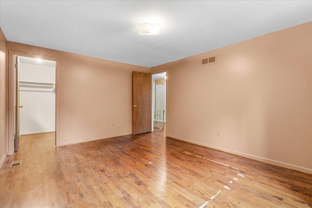 360 Wood Creek Dr, Howell, MI 48843 - unfurnished bedroom with light wood-style flooring, a spacious closet, and a closet