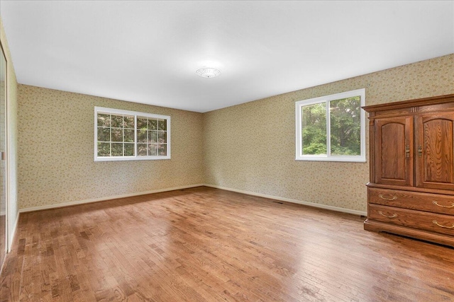 360 Wood Creek Dr, Howell, MI 48843 - unfurnished bedroom featuring wallpapered walls and light wood finished floors