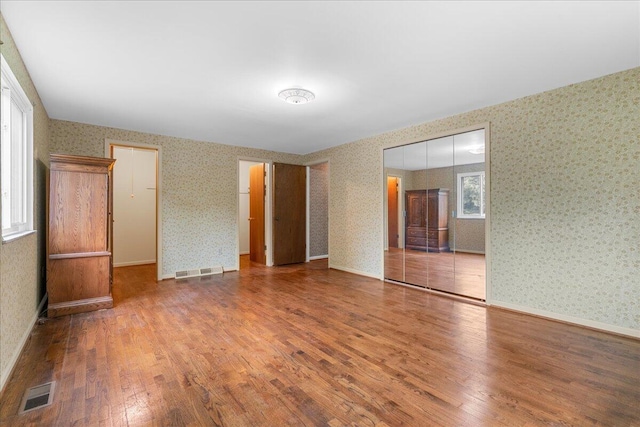 360 Wood Creek Dr, Howell, MI 48843 - spare room with hardwood / wood-style floors and wallpapered walls