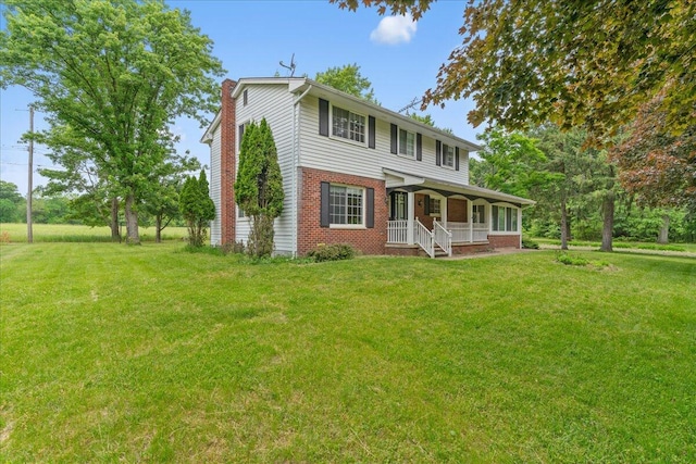360 Wood Creek Dr, Howell, MI 48843 - view of front of house with a chimney, brick siding, a porch, and a front yard