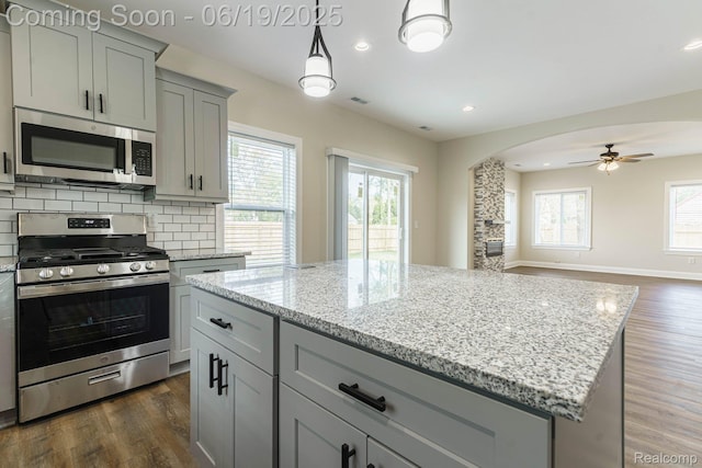 23013 Helen, Southfield, MI 48033 - kitchen featuring stainless steel appliances, gray cabinetry, arched walkways, dark wood-style floors, and a kitchen island