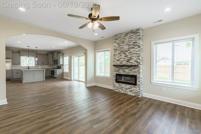 23013 Helen, Southfield, MI 48033 - unfurnished living room with dark wood-style floors, healthy amount of natural light, ceiling fan, a stone fireplace, and recessed lighting
