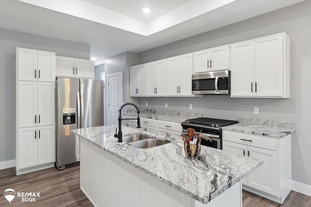 3113 Harbor Pointe Cir, Fenton, MI 48430 - kitchen featuring appliances with stainless steel finishes, white cabinetry, dark wood-style floors, light stone counters, and an island with sink