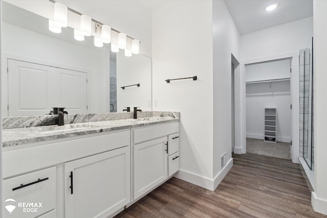 3113 Harbor Pointe Cir, Fenton, MI 48430 - full bathroom featuring double vanity, a spacious closet, wood finished floors, an enclosed shower, and recessed lighting