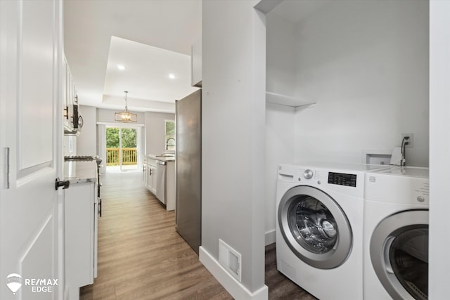 3113 Harbor Pointe Cir, Fenton, MI 48430 - laundry room featuring washing machine and dryer, light wood-style flooring, and recessed lighting