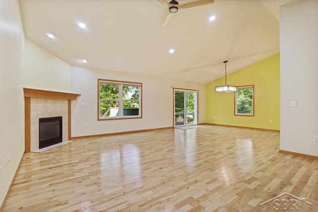 878 S Crooked Tree Ln, Midland, MI 48640 - unfurnished living room with light wood-type flooring, a ceiling fan, a tile fireplace, recessed lighting, and high vaulted ceiling