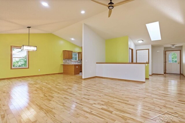 878 S Crooked Tree Ln, Midland, MI 48640 - unfurnished living room with vaulted ceiling, light wood-type flooring, a skylight, ceiling fan, and recessed lighting