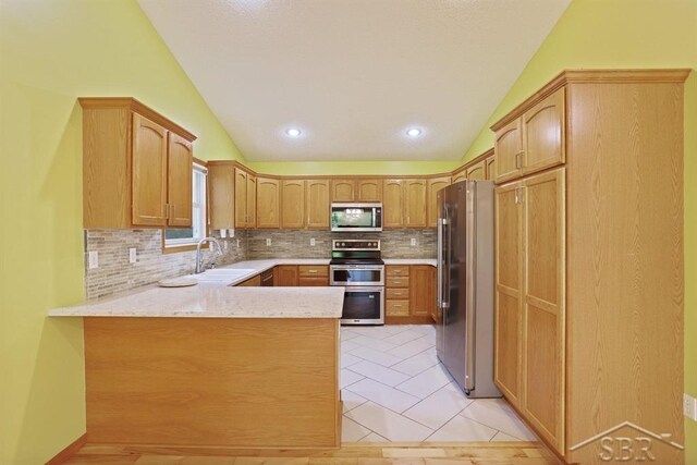 878 S Crooked Tree Ln, Midland, MI 48640 - kitchen featuring stainless steel appliances, vaulted ceiling, a peninsula, tasteful backsplash, and light tile patterned floors