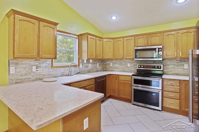 878 S Crooked Tree Ln, Midland, MI 48640 - kitchen with stainless steel appliances, a peninsula, vaulted ceiling, backsplash, and light tile patterned flooring