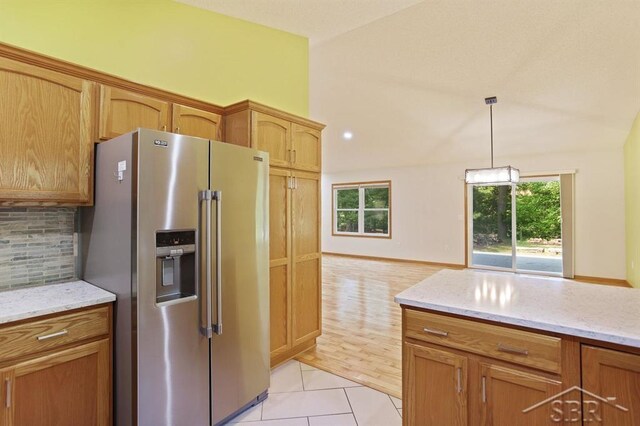 878 S Crooked Tree Ln, Midland, MI 48640 - kitchen with high quality fridge, backsplash, light tile patterned floors, light stone counters, and lofted ceiling