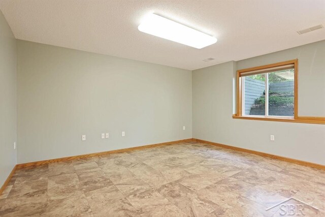 878 S Crooked Tree Ln, Midland, MI 48640 - spare room with a textured ceiling and stone finish floors