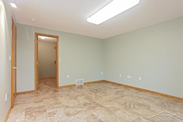 878 S Crooked Tree Ln, Midland, MI 48640 - empty room featuring baseboards and a textured ceiling