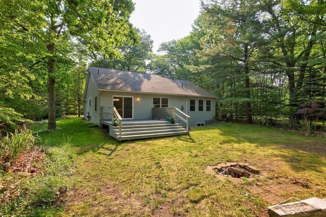 878 S Crooked Tree Ln, Midland, MI 48640 - rear view of property featuring a fire pit, a lawn, and a deck
