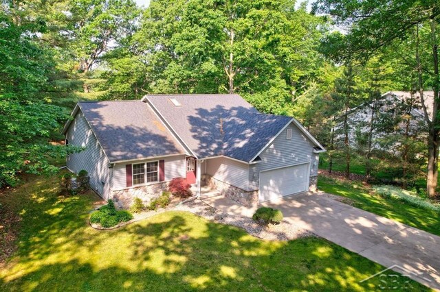 878 S Crooked Tree Ln, Midland, MI 48640 - ranch-style home with stone siding, an attached garage, roof with shingles, driveway, and a front yard