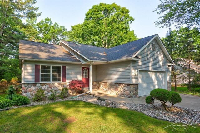 878 S Crooked Tree Ln, Midland, MI 48640 - single story home with stone siding, an attached garage, roof with shingles, and a front yard