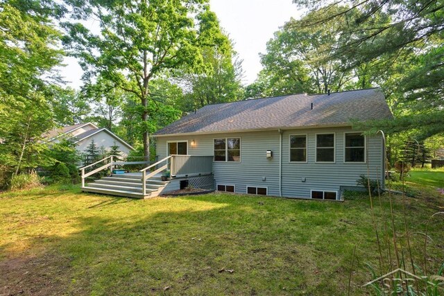 878 S Crooked Tree Ln, Midland, MI 48640 - back of property featuring a yard, a wooden deck, and a shingled roof