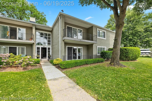 1111 N Old Woodward Ave, Birmingham, MI 48009 - view of front of home featuring brick siding, a front lawn, a chimney, and a balcony