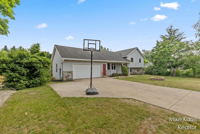 2742 Woodridge Dr, Jenison, MI 49428 - tri-level home featuring a fire pit, stone siding, a front yard, driveway, and a garage