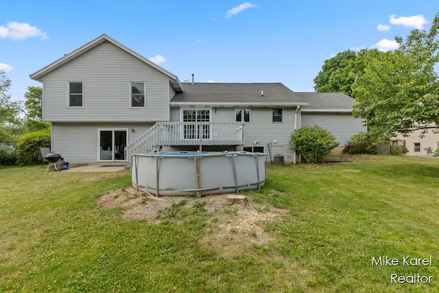 2742 Woodridge Dr, Jenison, MI 49428 - back of property with an outdoor pool, a lawn, a wooden deck, and a shingled roof