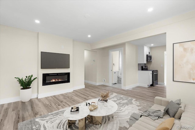 24270 Columbus Ave, Warren, MI 48089 - living room featuring light wood-type flooring, a glass covered fireplace, and recessed lighting