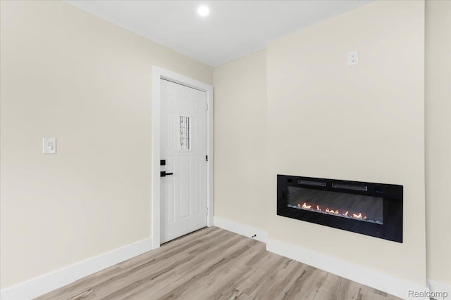 24270 Columbus Ave, Warren, MI 48089 - unfurnished living room featuring wood finished floors, a glass covered fireplace, and recessed lighting