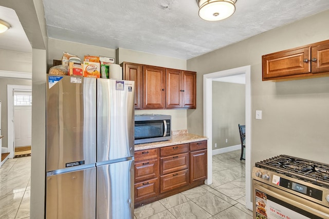 14311 Forrer St, Detroit, MI 48227 - kitchen with appliances with stainless steel finishes, light marble finish floors, and brown cabinetry