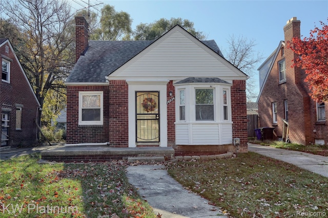 16054 Carlisle St, Detroit, MI 48205 - bungalow featuring roof with shingles, brick siding, and a chimney