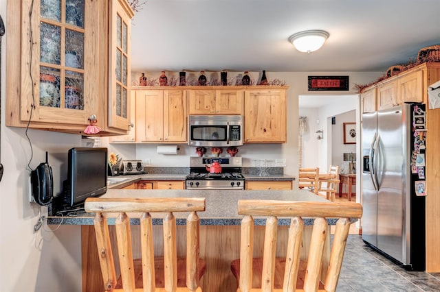 6360 Ray Rd, Swartz Creek, MI 48473 - kitchen with stainless steel appliances, light brown cabinetry, glass insert cabinets, dark countertops, and a peninsula