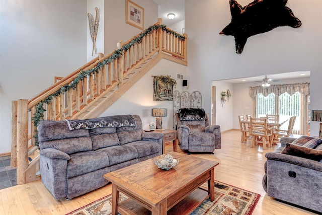 6360 Ray Rd, Swartz Creek, MI 48473 - living area featuring a towering ceiling, wood finished floors, stairway, and a ceiling fan