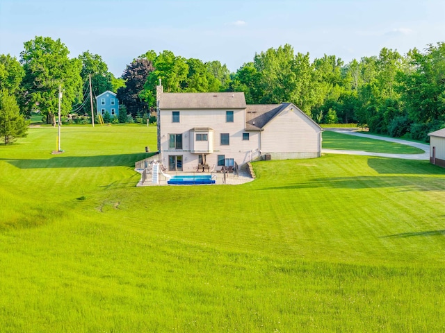 6360 Ray Rd, Swartz Creek, MI 48473 - rear view of house with a lawn, a patio area, and a chimney