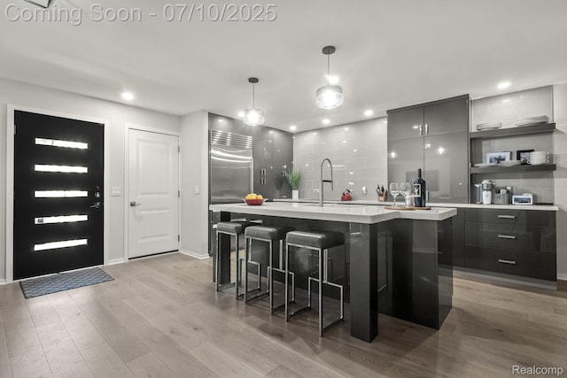 418 E 5th St Unit 2, Royal Oak, MI 48067 - kitchen with modern cabinets, light countertops, open shelves, light wood-style floors, and a breakfast bar