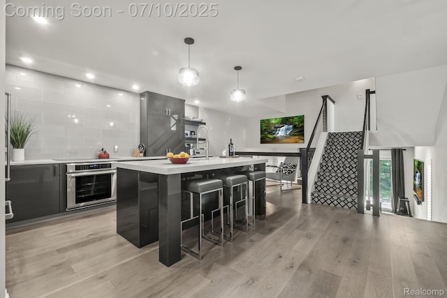418 E 5th St Unit 2, Royal Oak, MI 48067 - kitchen featuring stainless steel oven, light countertops, light wood-type flooring, modern cabinets, and recessed lighting