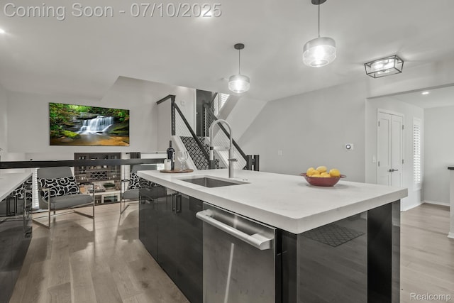 418 E 5th St Unit 2, Royal Oak, MI 48067 - kitchen featuring stainless steel dishwasher, dark cabinetry, light wood-type flooring, light countertops, and decorative light fixtures