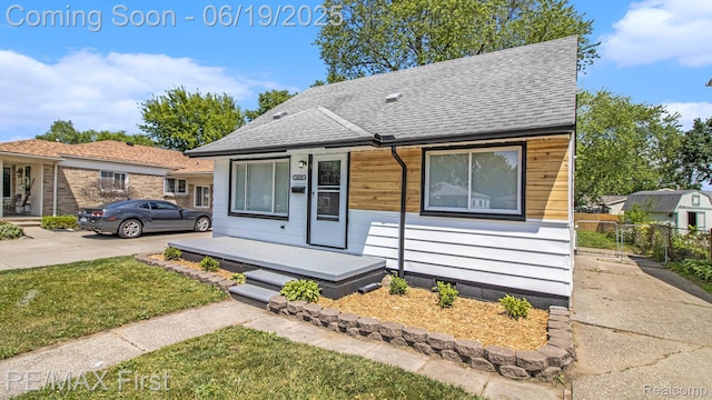 24520 Laetham Ave, Saint Clair Shores, MI 48021 - view of front facade featuring roof with shingles, driveway, and a porch