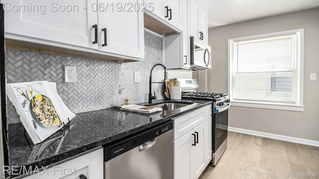 24520 Laetham Ave, Saint Clair Shores, MI 48021 - kitchen featuring stainless steel appliances, decorative backsplash, light wood-type flooring, white cabinets, and dark stone counters