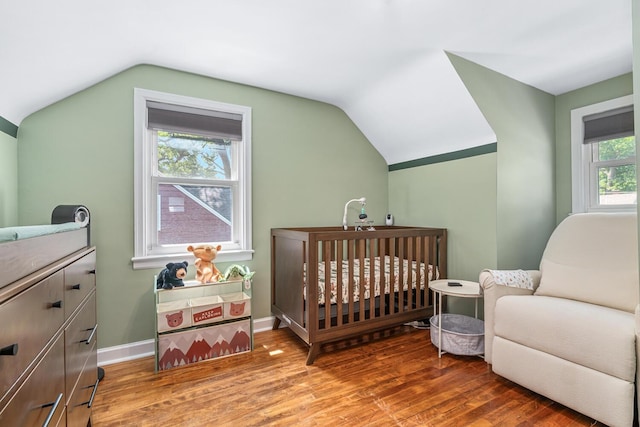 2646 Forest Grove Ave SW, Wyoming, MI 49519 - bedroom featuring wood finished floors, vaulted ceiling, and a crib