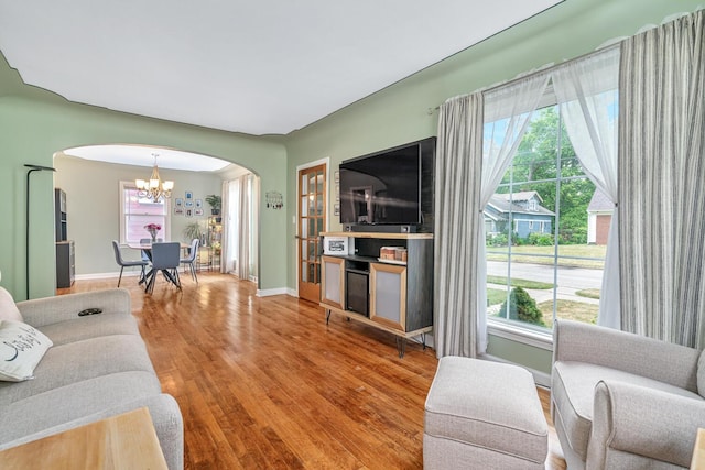 2646 Forest Grove Ave SW, Wyoming, MI 49519 - living area featuring arched walkways, a chandelier, healthy amount of natural light, and wood finished floors