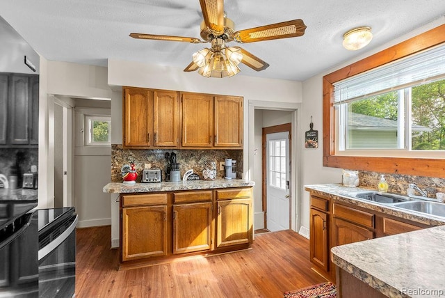 316 N Seymour Rd, Flushing, MI 48433 - kitchen featuring decorative backsplash, light wood-style floors, plenty of natural light, a ceiling fan, and a textured ceiling