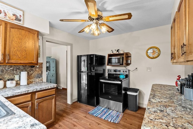 316 N Seymour Rd, Flushing, MI 48433 - kitchen with freestanding refrigerator, stainless steel electric range oven, a ceiling fan, light wood-style flooring, and tasteful backsplash
