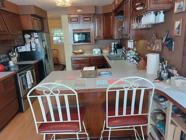 23675 N Shore Dr, Edwardsburg, MI 49112 - kitchen with electric stove, black microwave, light countertops, a peninsula, and light wood-style floors