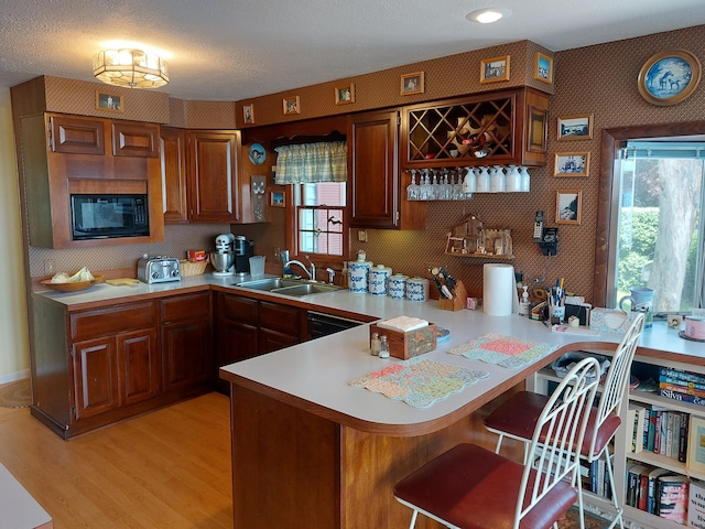 23675 N Shore Dr, Edwardsburg, MI 49112 - kitchen featuring black microwave, light countertops, light wood finished floors, healthy amount of natural light, and a textured ceiling